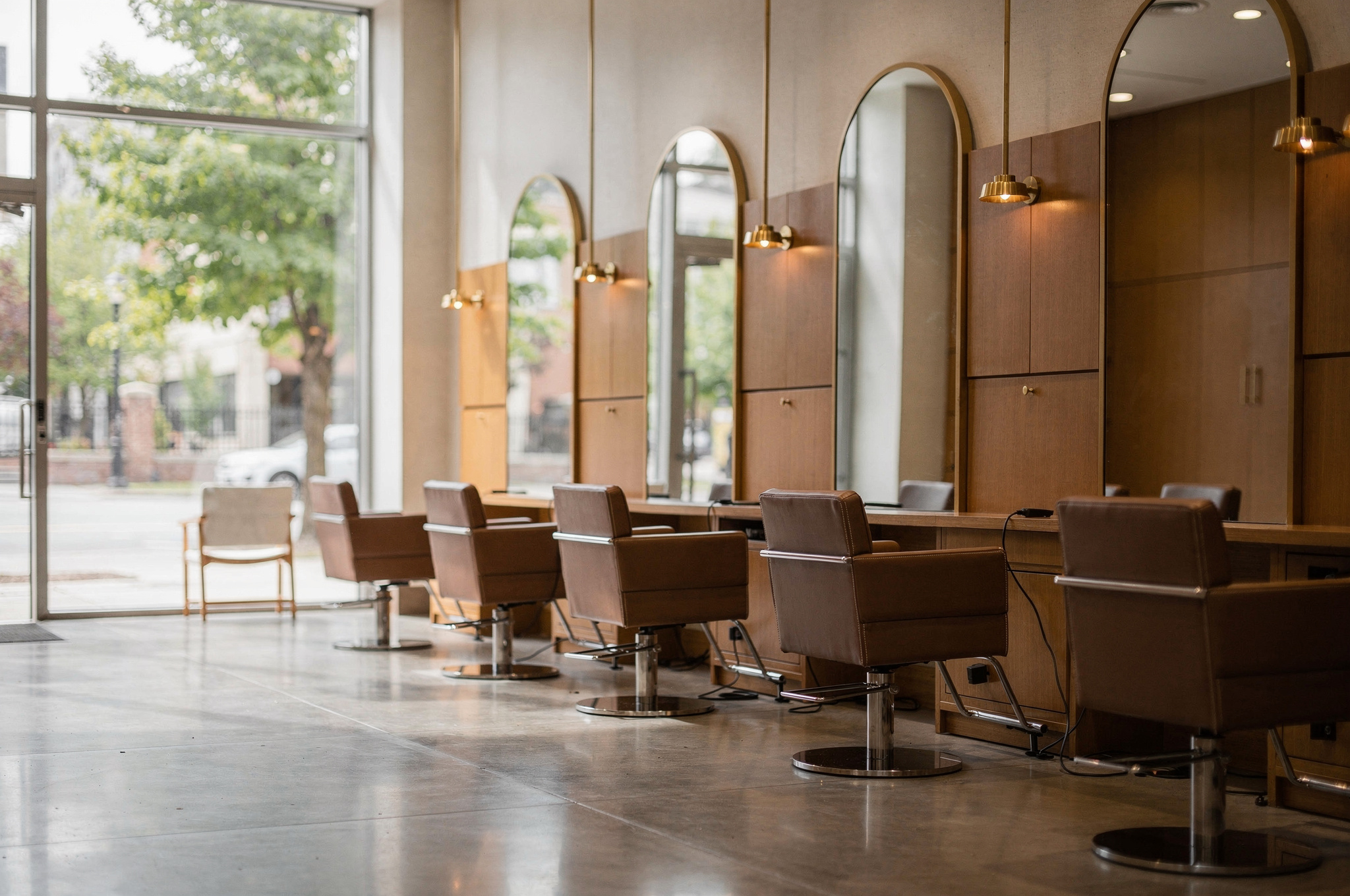 Upscale Surrey hair salon interior with warm wood tones, brass fixtures and empty styling chairs