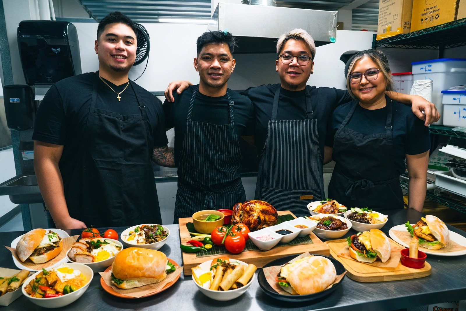 halina founders four friends HALINÁ Modern Filipino Kitchen + Bar The four friends behind Halina in black aprons, standing in the kitchen behind a table of plated Filipino dishes